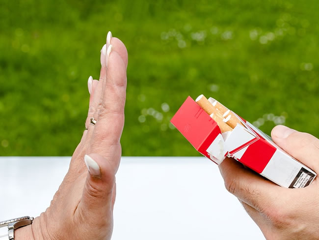 Una persona rechaza un cigarrillo para dejar de fumar sin engordar